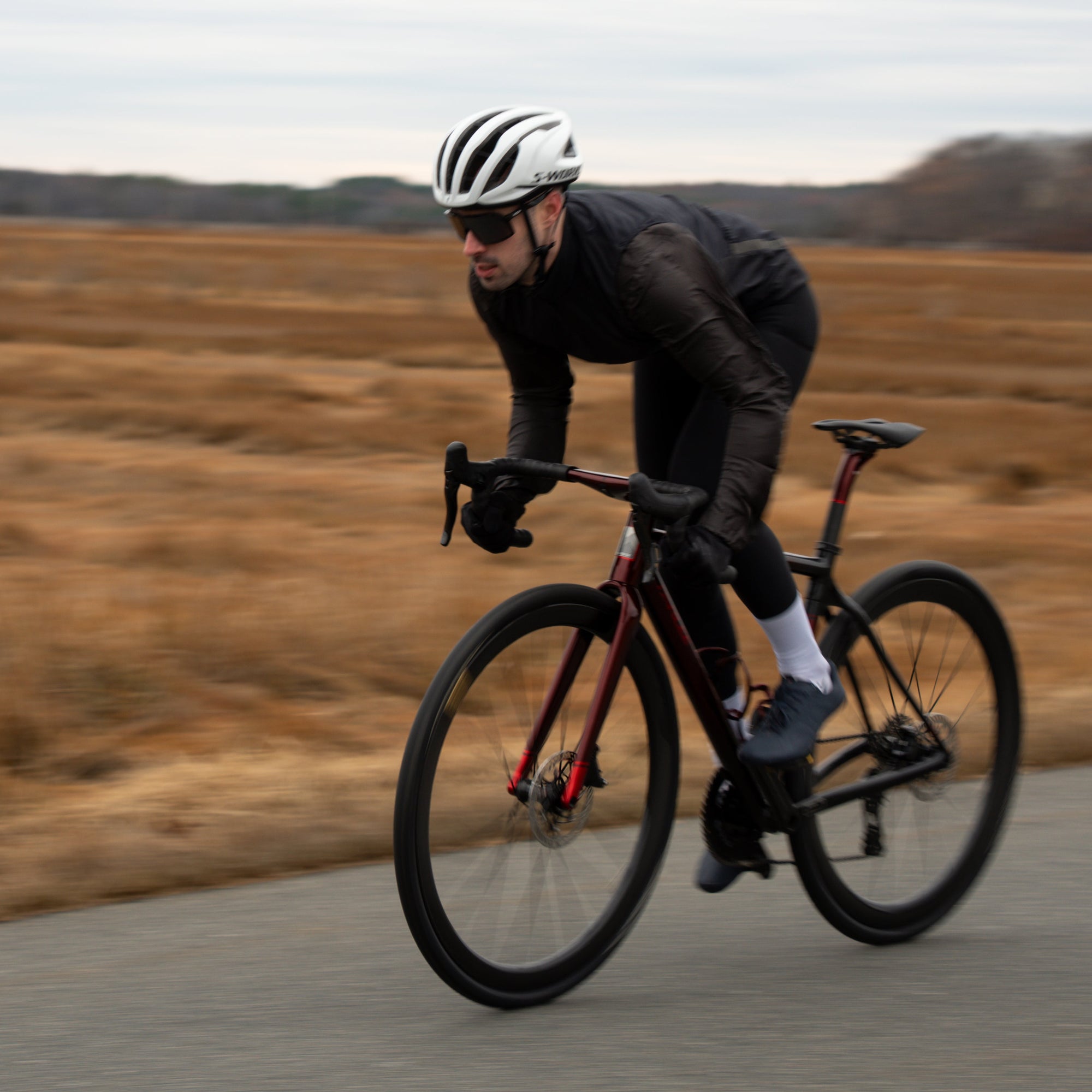 Person riding a bicycle on a road with a blurred natural background